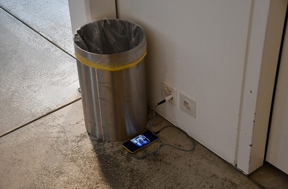 Documentation infiltrée de la performance de Jérome Leuba battlefield #146, sur le site où elle a eu lieu durant deux jours. Images animées documentant la performance, visibles sur un téléphone posé sur le sol en train de charger à l’entrée du Fotomuseum Winterthur pour l’exposition Street. Life. Photography, 2020.